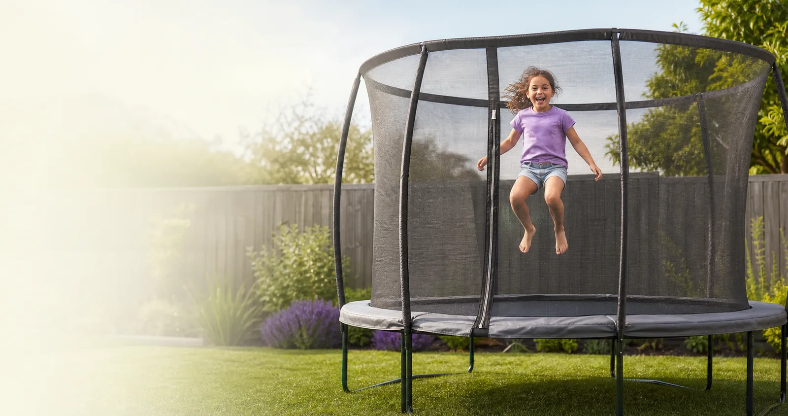 A child happily and safely bouncing inside an enclosed backyard trampoline